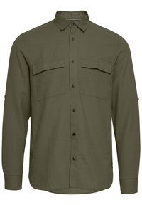 Camicia a maniche lunghe verde oliva con chiusura a bottoni sul davanti, due tasche sul petto e orlo curvo. Realizzata in un tessuto texturizzato. Bottoni neri.