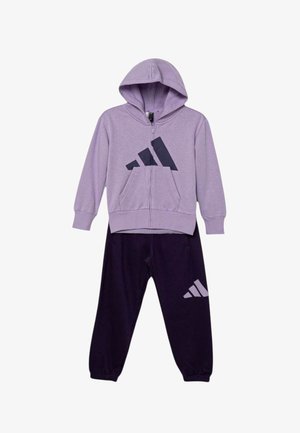 Sudadera con capucha morada con cremallera y un gran logo azul marino en el pecho, combinada con pantalones deportivos morados oscuros que tienen un logo más pequeño en la pierna.