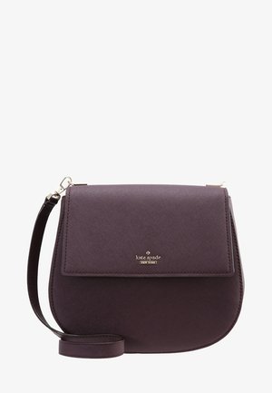 Ciemnofioletowa torebka na ramię Kate Spade z klapą, złotymi okuciami i regulowanym paskiem, logo wyśrodkowane na przedniej klapie.