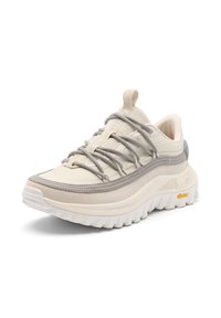 Beige-grauer Sportschuh mit dicker weißer Vibram-Sohle, Mesh-Obermaterial, Schlaufe an der Zunge und verflochtenen grauen Schnürsenkeln.