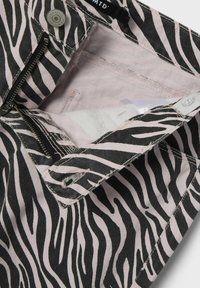 Pantalons en denim noir et rose à motif zèbre, avec une fermeture éclair, des coutures solides et une doublure intérieure douce.