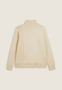 Maglione crema con collo alto, polsini e orlo a costine, e dettagli di cucitura a pannello sul retro. Texture liscia.