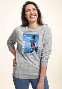 Felpa grigia con una grafica blu di un alpinista, "SINCE 1981," e un design a forma di bussola. Tessuto morbido con polsini e orlo a costine.