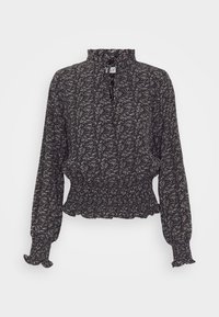 Blusa floreale bianco e nero con colletto alto, lunghe maniche a sbuffo e vita arricciata; tessuto leggero con un aspetto testurizzato.