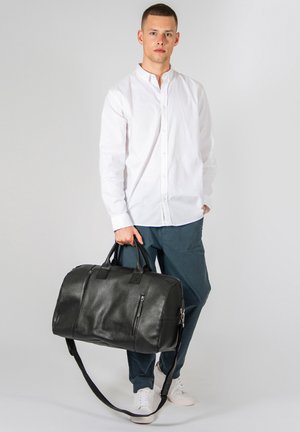 Schwarze Leder-Duffel-Tasche mit zwei oberen Griffen, einem abnehmbaren Schultergurt und zwei Reißverschlusstaschen auf der Vorderseite. Glatte Textur, geräumiges Design.
