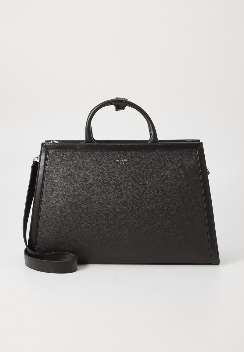 Geantă din piele neagră, cu o structură rigidă, dotată cu mânere superioare, curea pentru umăr detașabilă și text discret al brand-ului în centrul frontal.