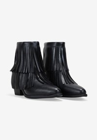 Botas de tobillo negras de cuero con detalles de flecos, punta redondeada y un tacón bajo en bloque. Textura suave sin patrones visibles.