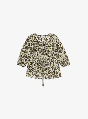 Blouse en tissu transparent à imprimé léopard, avec un col rond, des manches longues et un détail à nouer à l'avant. Les couleurs incluent le jaune, le noir et le blanc.