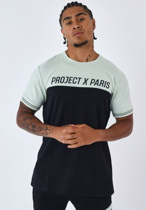 Camiseta de manga corta en verde menta y negro, con "PROJECT X PARIS" en letras en negrita, con acentos a rayas en las mangas y un corte relajado.
