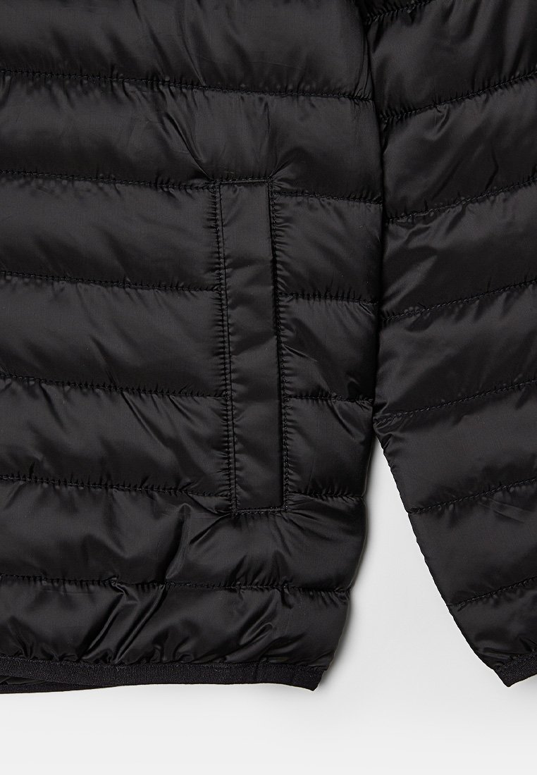 Giacca a vento nera con design trapuntato, texture liscia, polsini elasticizzati e tasca nascosta sul lato sinistro.