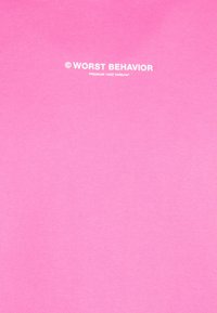 Sudadera rosa hecha de suave tela de algodón. Presenta texto blanco que dice "© WORST BEHAVIOR" y "PREMIUM 120Z 340Gr/m²."