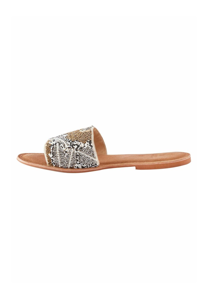 Flache Riemensandalen mit einem beaded Riemen in Gold, Silber und Weiß sowie einer braunen Ledersohle. Schlichte Form mit offenen Zehen.