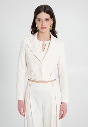 Gekürzter weißer Blazer mit Spitzrevers, goldenen Hardwareakzenten und einer Frontverschluss. Glattes Material mit enganliegenden langen Ärmeln.