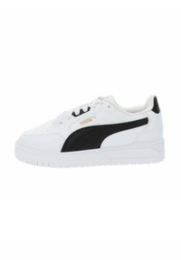 White sneaker with black accents and logo; smooth leather upper, round toe, flat sole, and lace-up closure. Gold branding detail visible.