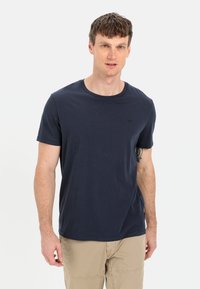 Mørkeblå bomulds T-shirt med rund hals, korte ærmer og et lille logo på brystet. Glat tekstur, afslappet pasform.