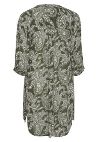 Blouse vert olive avec imprimé cachemire blanc, en tissu léger. Comprend des manches trois-quarts et des fentes latérales pour faciliter les mouvements.