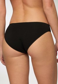 Bikini briefs neri in cotone con una texture liscia e design a vita bassa, caratterizzati da cuciture minime e un taglio classico per il massimo del comfort.