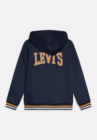 Navyblauwe hoodie met een groot oranje "LEVI'S" logo. Heeft horizontale gestreepte ribbels in wit, oranje en navy aan de zoom en mouwen.