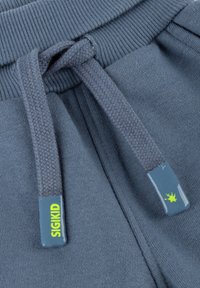 Navy blue cotton joggers featuring a ribbed waistband, braided drawstrings, and a plastic logo tag with a neon green accent.