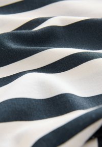 Cotton fabric with dark blue and white horizontal stripes. Smooth texture with gentle waves and subtle sheen.