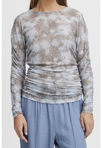 Långärmad topp i ljusblått och beige ormskinnsmönster, med rynkad design och rund halsringning. Tillverkad av stretchigt tyg.