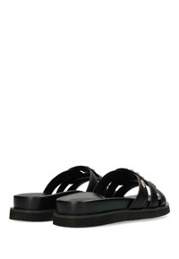 Svarta sandaler med flera korsande remmar, platt sula och guldfärgad hårdvara. Tillverkade av ett slätt material med matt yta.