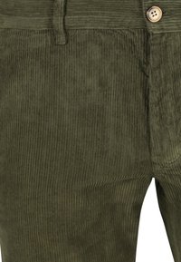 Close-up of olive green corduroy pants showing fabric texture, waistband, belt loop, button, and front pocket detail.