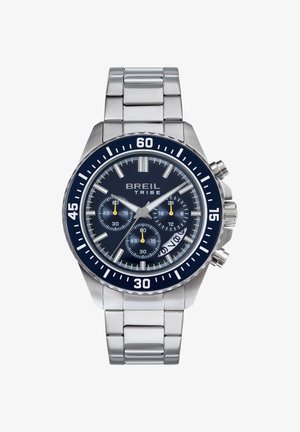 Rustfrit stål ur med en marineblå urskive, tre sub-urskiver og lysende timemarkører. Har en roterende bezel og sølvfarvet rem.