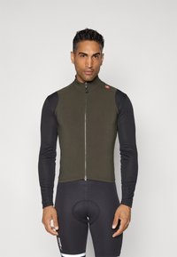 Fietsvest in olijfgroen, met een hoge kraag, rits aan de voorkant, en gecombineerd met zwarte lange mouwen. Getextureerde stof, atletische pasvorm.
