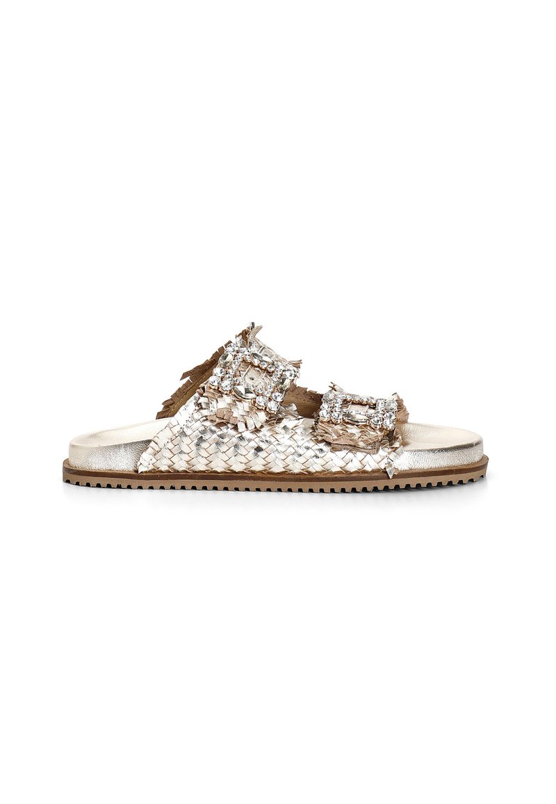 Woven metallic slide sandal in shades of gold and beige, featuring two oversized buckles adorned with clear rhinestones. Textured sole.