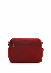 Sarkana auduma krustneša soma ar plakanu, taisnstūra formu. Aprīkota ar priekšējo rāvējslēdzēja kabatu un sānu kabatu. Gluda tekstūra un minimāls aparatūras daudzums.