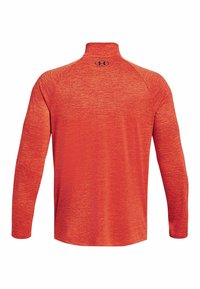 Long-sleeve, red athletic pullover with high collar and black Under Armour logo on upper back.