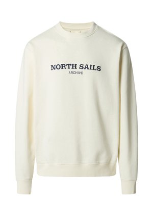 Sweat-shirt crème à col rond avec poignets et ourlet côtelés, arborant l'inscription "NORTH SAILS ARCHIVE" brodée en bleu marine sur la poitrine.
