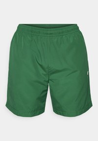 Bañador verde hasta la rodilla, fabricado con un tejido ligero y suave, con una cintura elástica y un pequeño logo como acento.