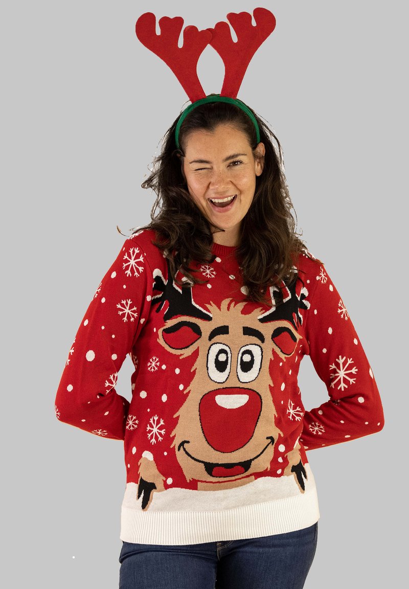 Roter Strickpullover mit Rentierdesign, weißen Akzenten und Schneeflockenmuster. Ein grünes Geweih-Kopfband vervollständigt den festlichen Look.