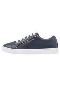 Sneaker in pelle blu navy con lacci bianchi, suola in gomma bianca e dettaglio decorativo a righe. Presenta un logo dettagliato sul lato.