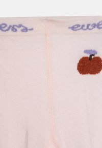 Hellrosa Socken mit gerippter Textur, die ein kleines braunes Apfeldesign und lila Nähte am oberen Rand aufweisen.