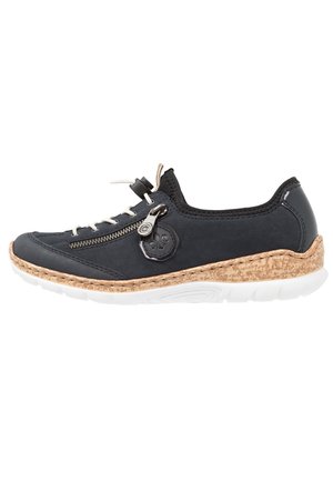 Black sneaker with cork sole, textured leather upper, front zipper, and white laces. Features logo and stitching detail across the body.