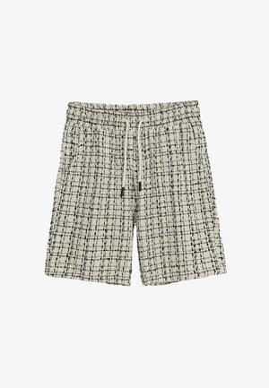 Shorts à carreaux noirs et blancs avec une taille élastique et un cordon de serrage, dotés d'un tissu texturé et d'une coupe décontractée.