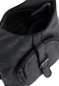 Zwart leren tas met een gestructureerde afwerking, voorzien van een bovenste ritsluitingen, een externe ritszak en een compact ontwerp.