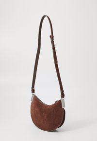 Borsa in suede marrone con forma curva, dotata di chiusura con zip e tracolla in pelle marrone. La borsa presenta cuciture decorative minime.