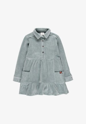 Vestido de pana en azul gris claro con un cierre de botones en la parte frontal, cuello, dos bolsillos, una falda en capas y una etiqueta de tela en el bolsillo izquierdo.