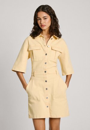 Robe en denim jaune à manches courtes avec un devant à boutons, deux poches poitrine, des poches latérales et une longueur mini, dotée d'un col.