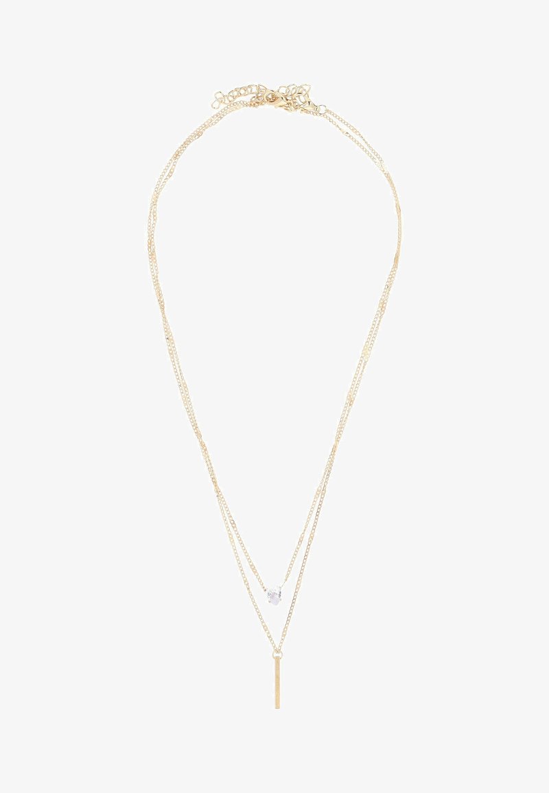 Guldtonet lagdelt halskæde med to delikate kæder, en med en krystalaccent og en stangvedhæng, som viser et stilrent, minimalistisk design.