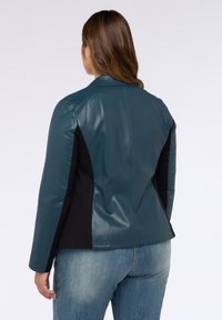 Tyrkysová kožená bunda s černými bočními panely, klopovým límcem a dlouhými rukávy, s přilnavým střihem a hladkou texturou.