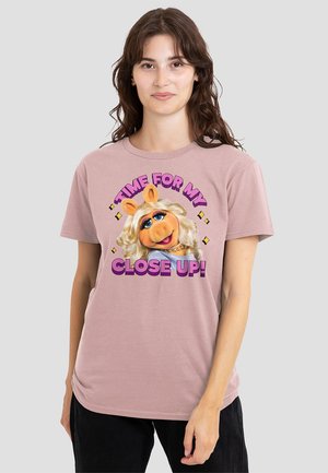 Helles rosa Baumwoll-T-Shirt mit einem Grafikdruck eines Cartoon-Charakters mit blonden Haaren und dem Text "JETZT BIN ICH DRAN!" in kräftigen Farben.