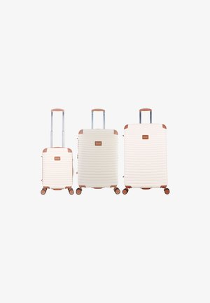 Three cream-colored hard-shell suitcases with brown handles and wheels, arranged from small to large, each with an extended telescopic handle.