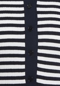 Cardigan a righe blu navy e bianche con texture a coste, caratterizzato da sei bottoni neri sul davanti. Il motivo alterna righe larghe e strette.
