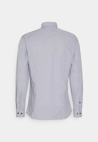 Vue arrière d'une chemise habillée à manches longues, gris clair, avec poignets boutonnés et col standard sur un fond uni.