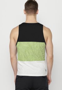 Medvilninis be rankovių marškinėlis su juodu viršutiniu ruožu, žaliu dryžuotu viduriniu ruožu ir baltu apatiniu ruožu. Savybės: apvalus kaklo išpjovimas.